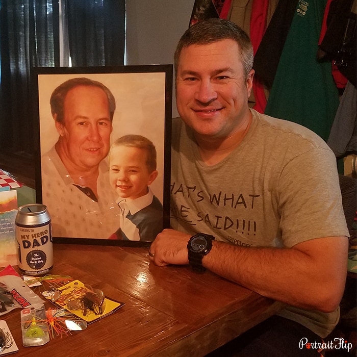 Picture of a man holding memorial portraits that show a man with a young boy