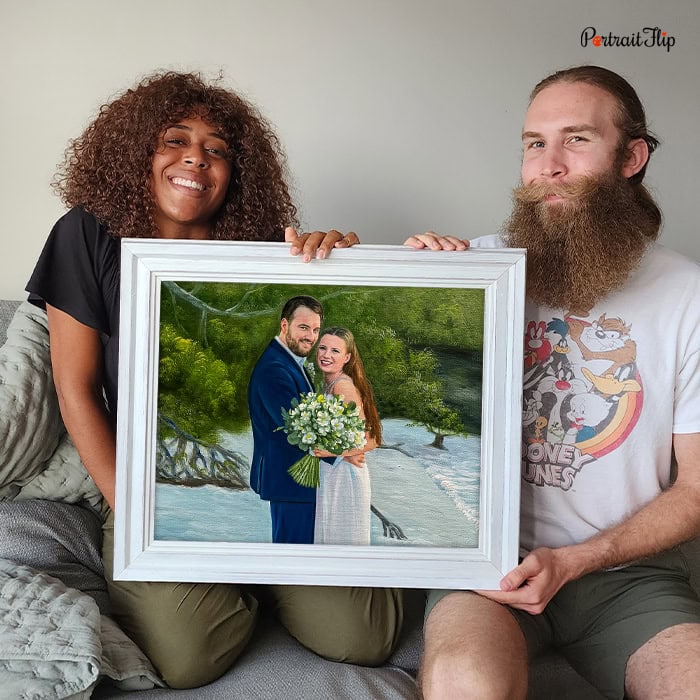 Couple holding their custom wedding portrait painting